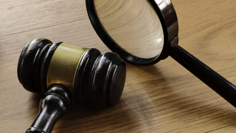 Gavel and magnifying glass symbolizing review of clear charity appeals and fundraising practices.