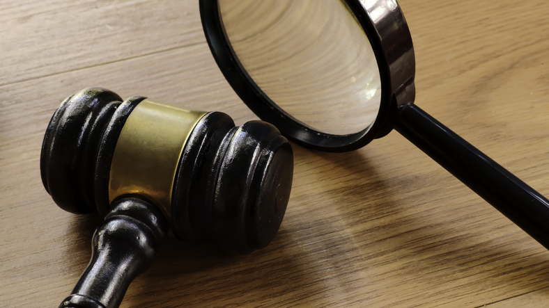 Gavel and magnifying glass symbolizing review of clear charity appeals and fundraising practices.