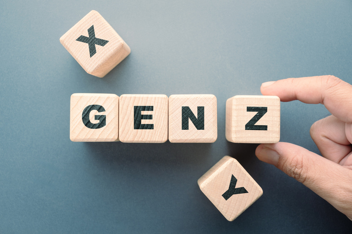 Hand arranging wooden blocks spelling Gen Z, representing the next generation of charitable donors.