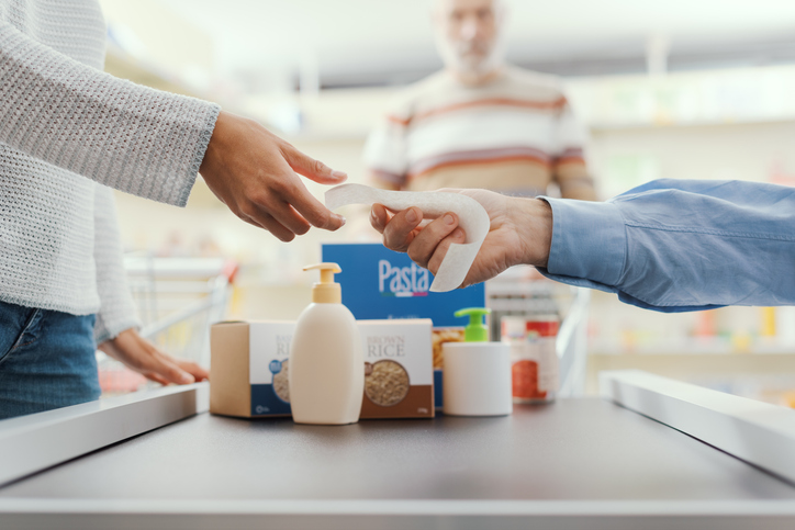 Customer receiving a receipt at a grocery store checkout where shoppers may be asked to round up for charity.