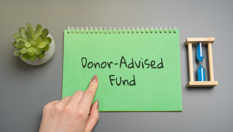 Home office workspace with notepad featuring the words “Donor Advised Fund.